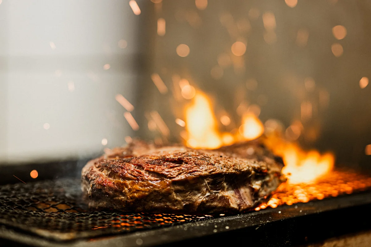 Ribeye som grilles over flammer hos Trondheim Biffhus